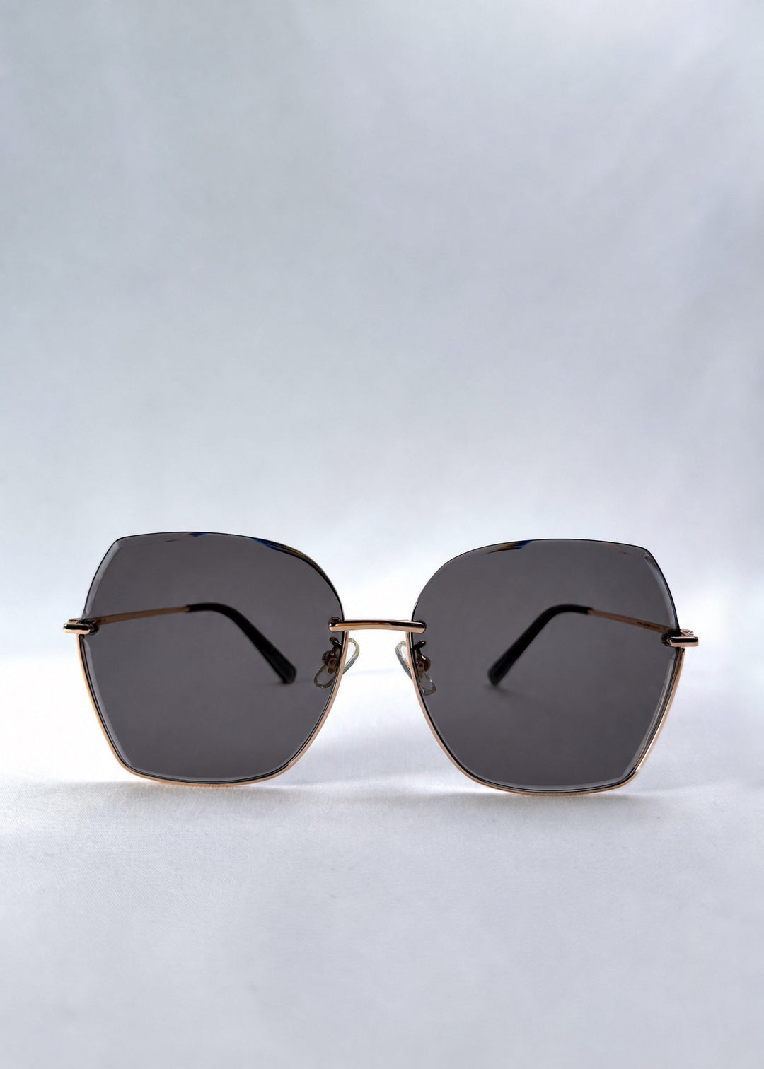 Front view of Aureon sunglasses in Silver Smoke, featuring rimless metal frame, silver temples, and grey lenses, showing the full front silhouette. 
