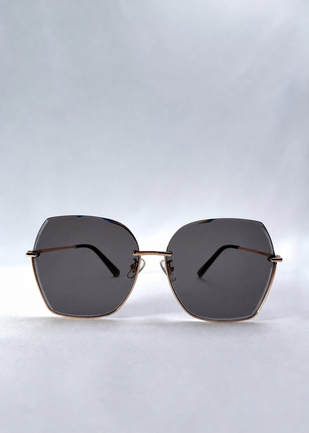 Front view of Aureon sunglasses in Silver Smoke, featuring rimless metal frame, silver temples, and grey lenses, showing the full front silhouette.