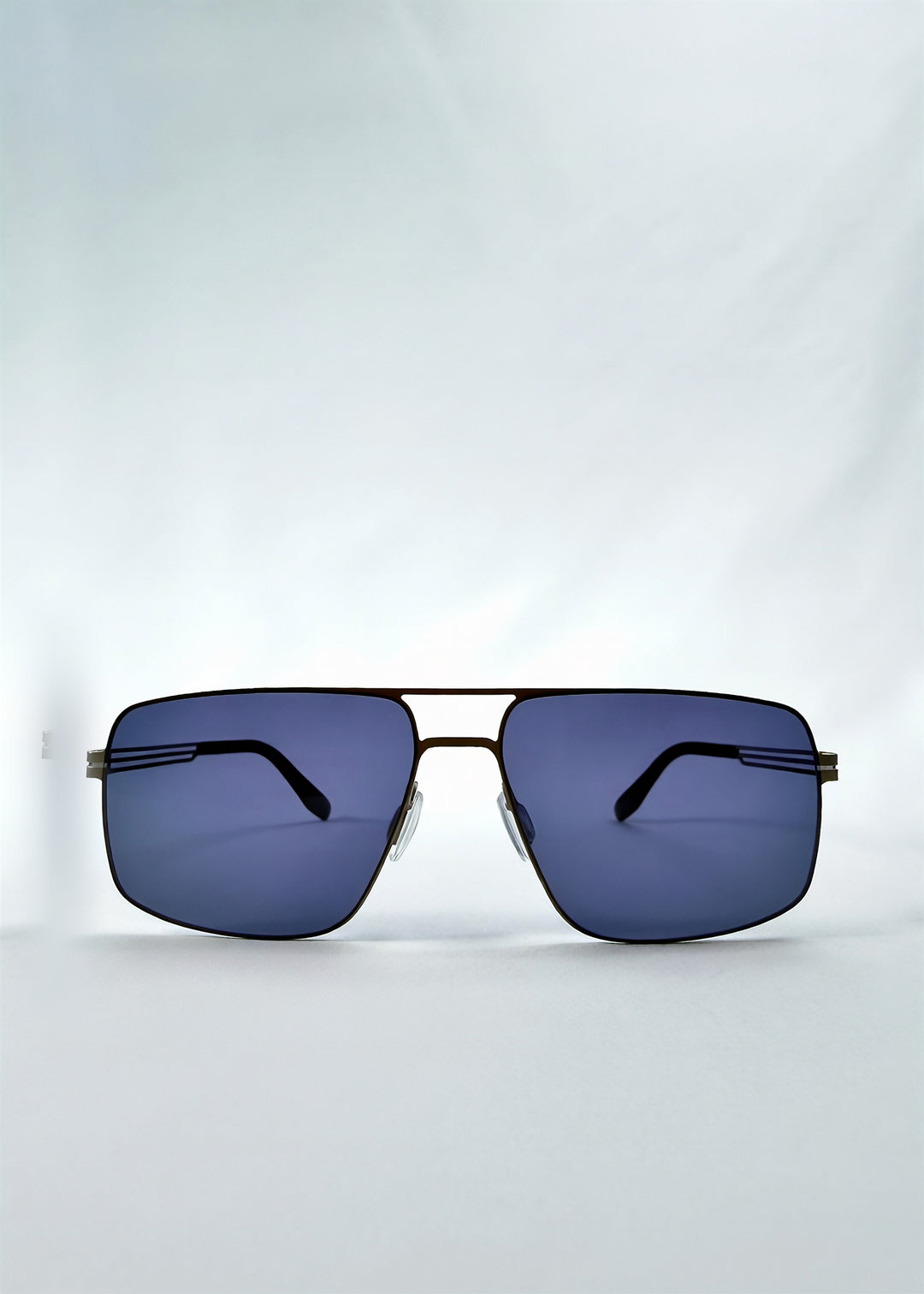 Front view of Axiom sunglasses in Blue Graphite, featuring blue-graphite rectangular metal frame and blue tinted polarized lenses, showing the full front silhouette.