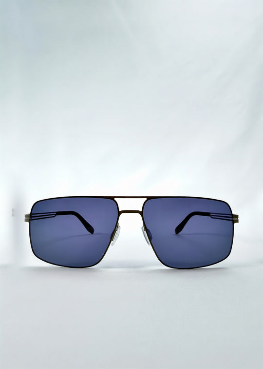 Front view of Axiom sunglasses in Blue Graphite, featuring blue-graphite rectangular metal frame and blue tinted polarized lenses, showing the full front silhouette.