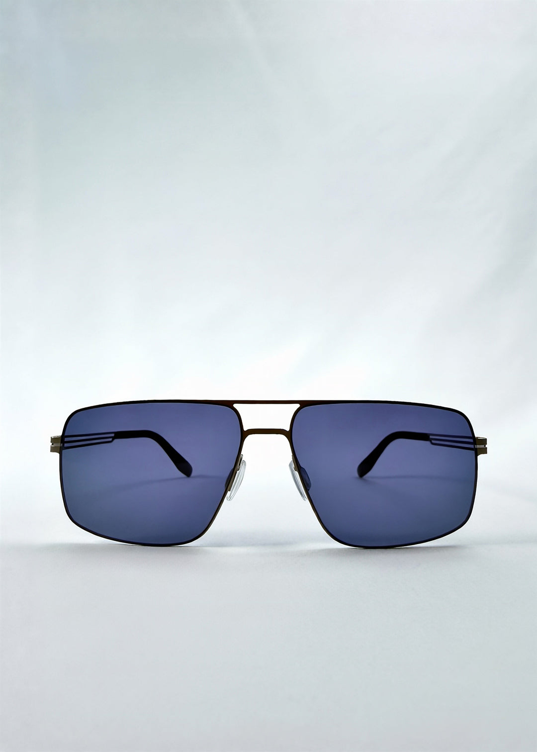 Front view of Axiom sunglasses in Blue Graphite, featuring blue-graphite rectangular metal frame and blue tinted polarized lenses, showing the full front silhouette. 