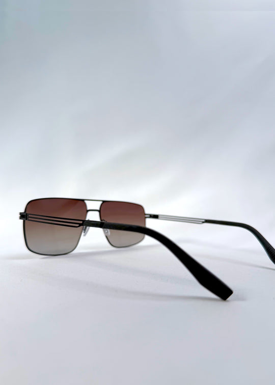 Back-angle view of Axiom sunglasses in Eclipse Black, featuring dark rectangular metal frame and shadowed gradient polarized lenses, showing the back structure and temple alignment.