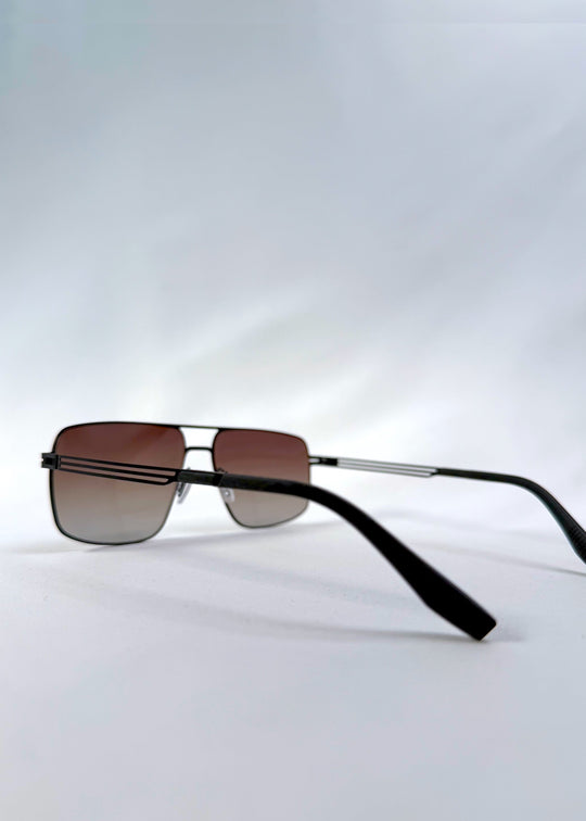 Back-angle view of Axiom sunglasses in Eclipse Black, featuring dark rectangular metal frame and shadowed gradient polarized lenses, showing the back structure and temple alignment. 