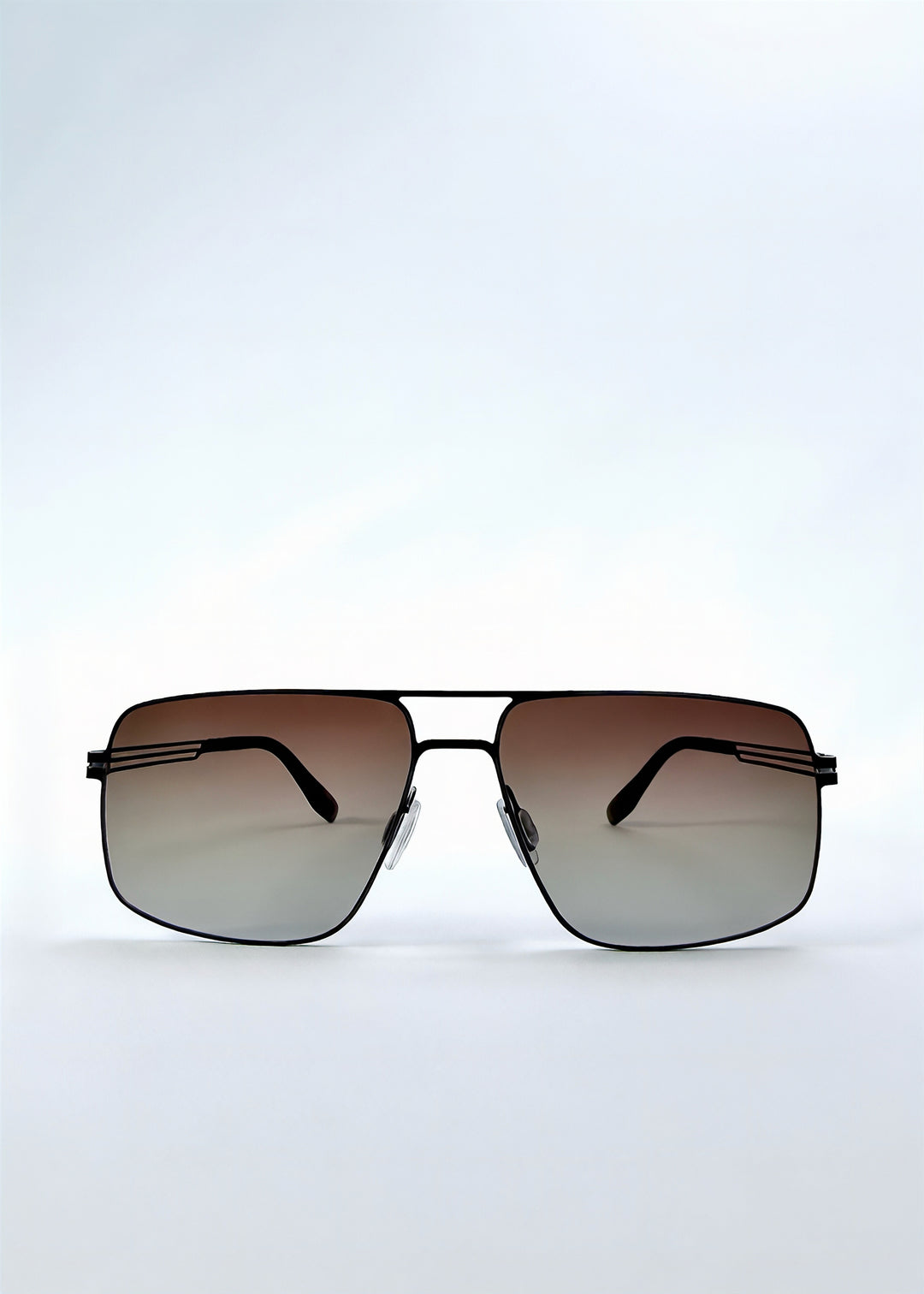 Front view of Axiom sunglasses in Eclipse Black, featuring dark rectangular metal frame and shadowed gradient polarized lenses, showing the full front silhouette.