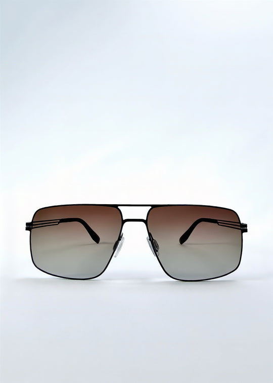 Front view of Axiom sunglasses in Eclipse Black, featuring dark rectangular metal frame and shadowed gradient polarized lenses, showing the full front silhouette. 