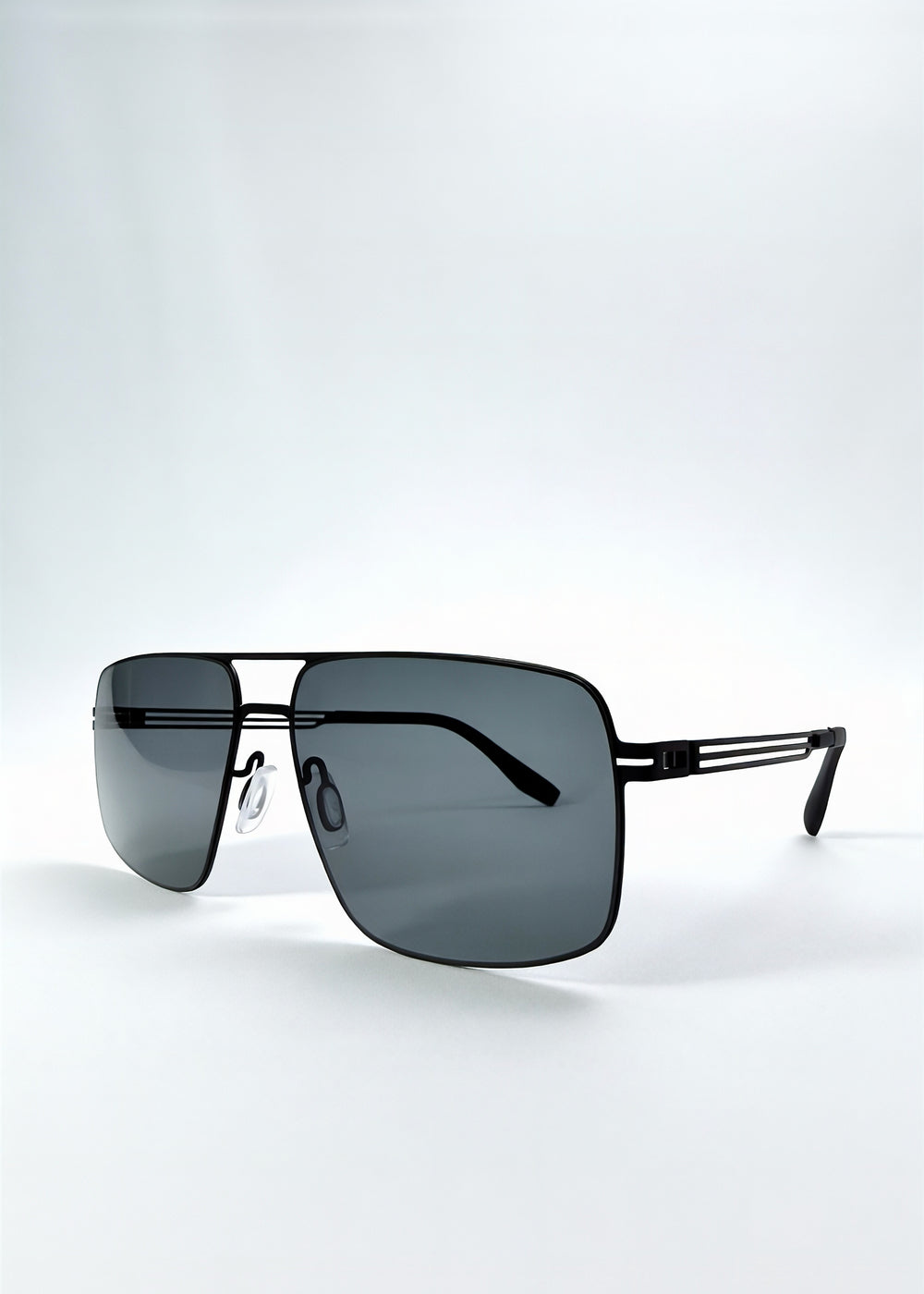 Three-quarter front view of Axiom sunglasses in Matte Black, featuring matte black rectangular metal frame and grey polarized lenses, showing the front shape and temple profile.