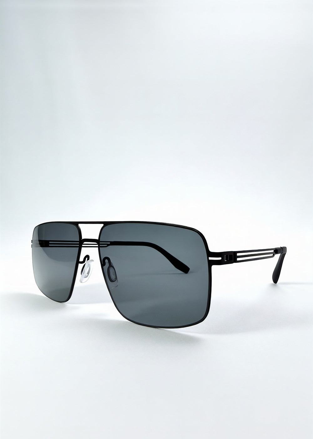 Three-quarter front view of Axiom sunglasses in Matte Black, featuring matte black rectangular metal frame and grey polarized lenses, showing the front shape and temple profile. #color_matte-black