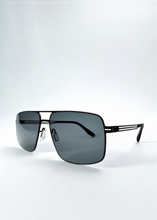 Three-quarter front view of Axiom sunglasses in Matte Black, featuring matte black rectangular metal frame and grey polarized lenses, showing the front shape and temple profile. 
