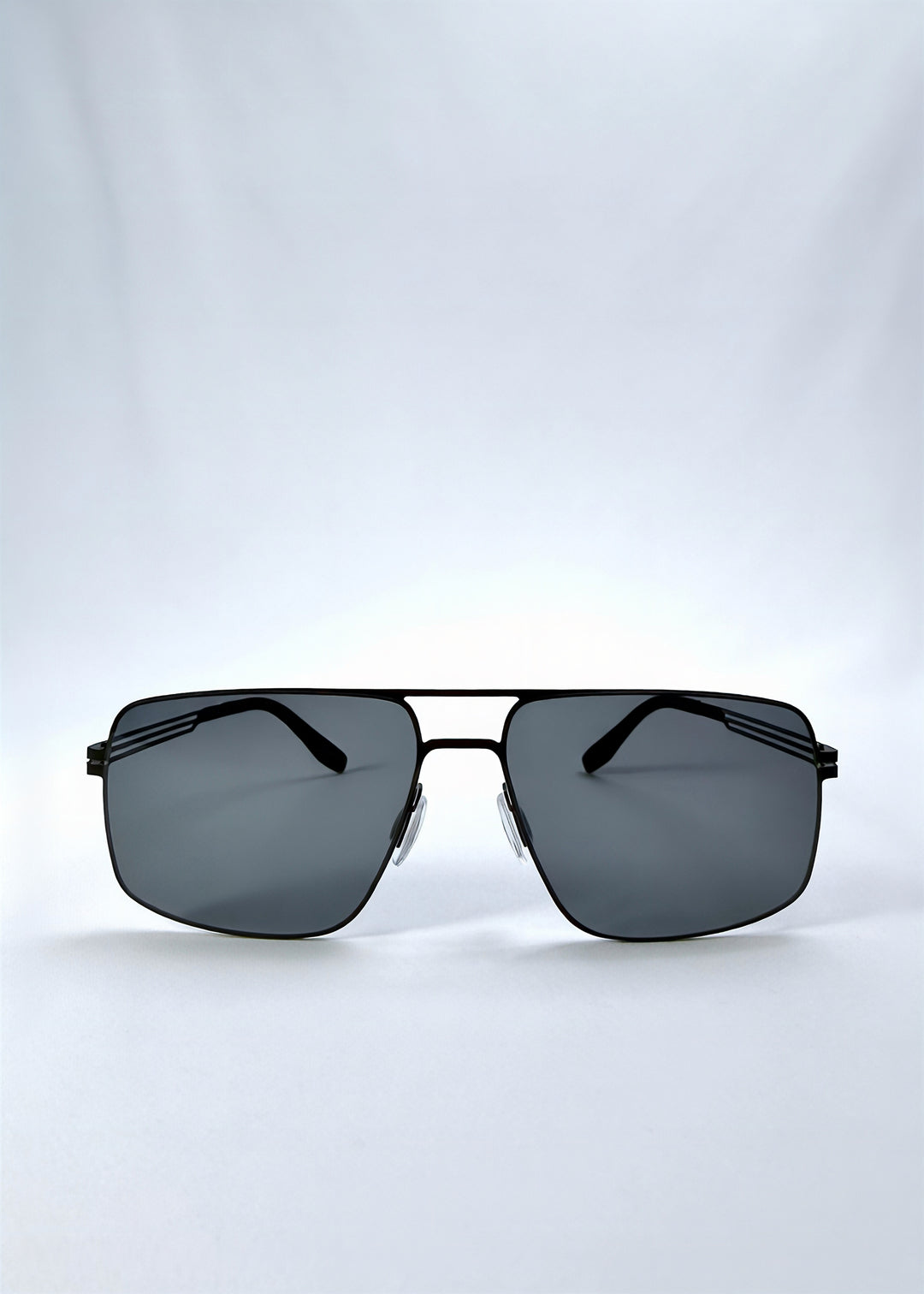 Front view of Axiom sunglasses in Matte Black, featuring matte black rectangular metal frame and grey polarized lenses, showing the full front silhouette.