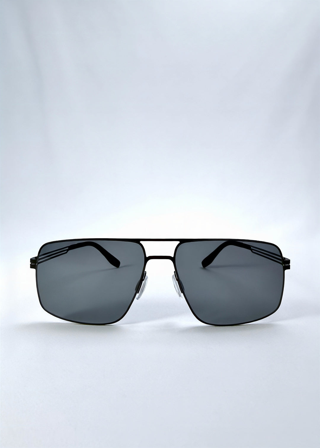 Front view of Axiom sunglasses in Matte Black, featuring matte black rectangular metal frame and grey polarized lenses, showing the full front silhouette. 