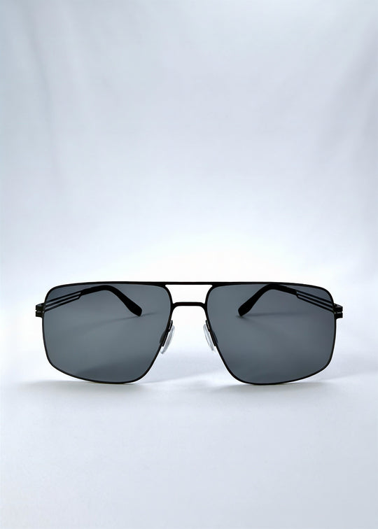 Front view of Axiom sunglasses in Matte Black, featuring matte black rectangular metal frame and grey polarized lenses, showing the full front silhouette. 