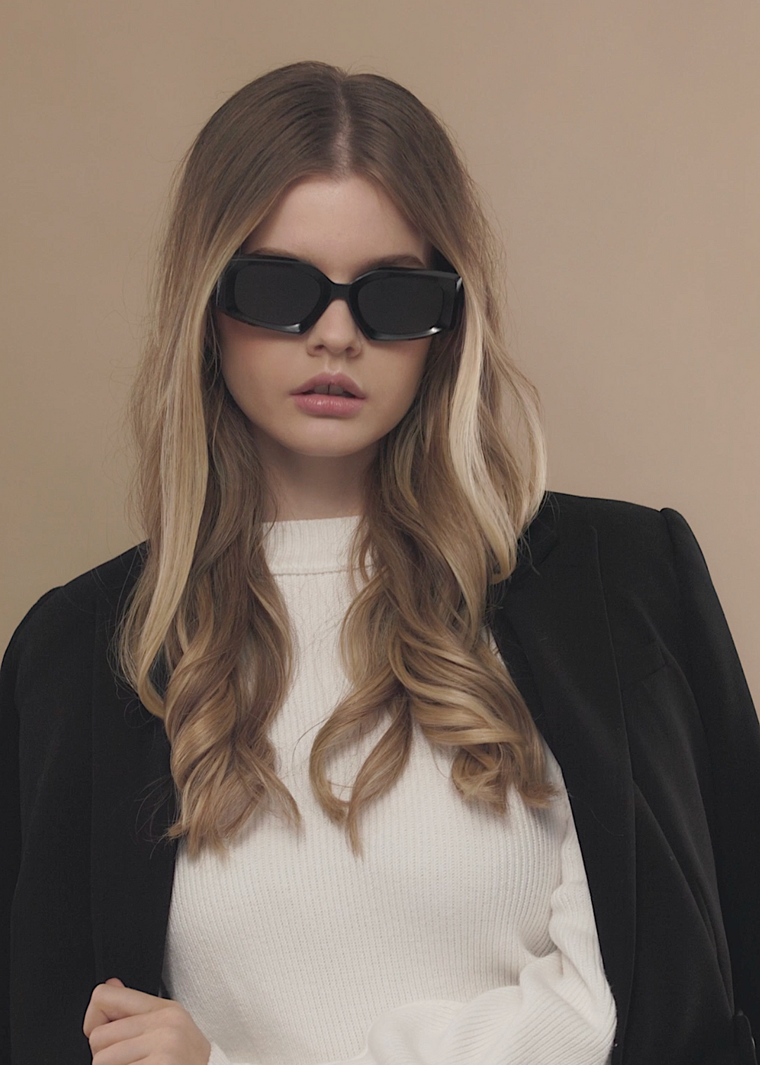 Female model wearing Bellatrix black sunglasses, emphasizing the bold and elegant oversized acetate frame. 