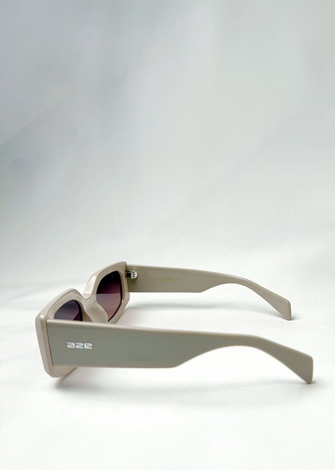 Side view of Bellatrix warm taupe sunglasses showcasing thick acetate temples and sleek, modern design. 