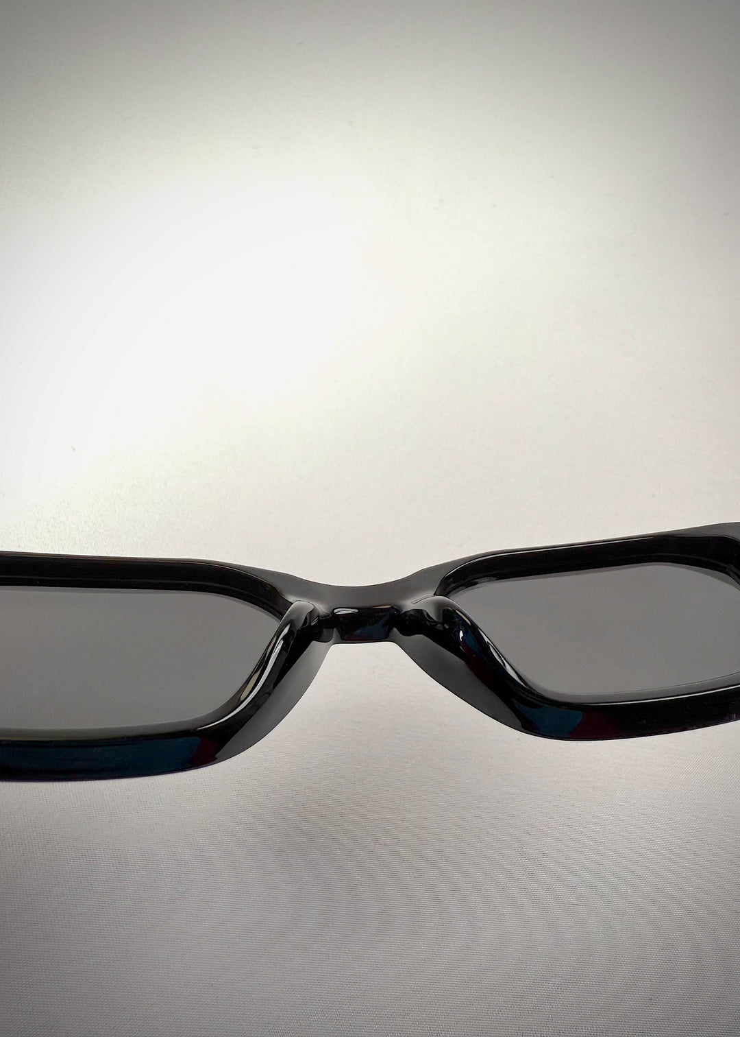 Close-up view of the nose bridge on Castor Black acetate prescription sunglasses, showcasing the glossy black frame and precision craftsmanship. 