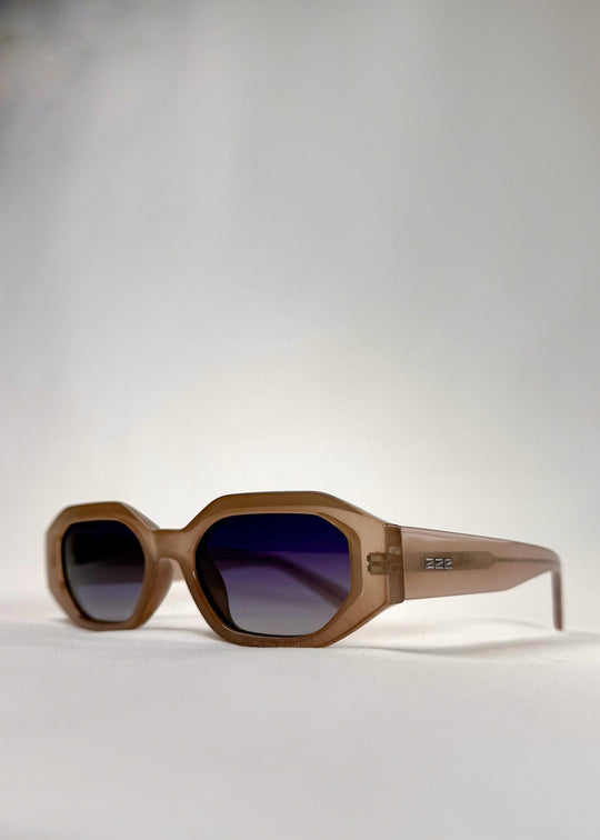 Close-up of Castor Champagne sunglasses, showing gradient blue lenses and refined craftsmanship. 