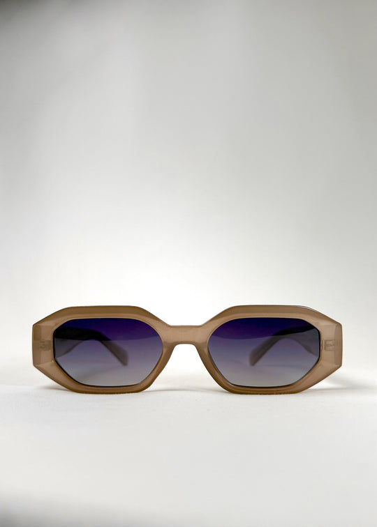 Front view of Castor sunglasses in Champagne with a translucent champagne acetate frame and blue gradient polarized lenses. 
