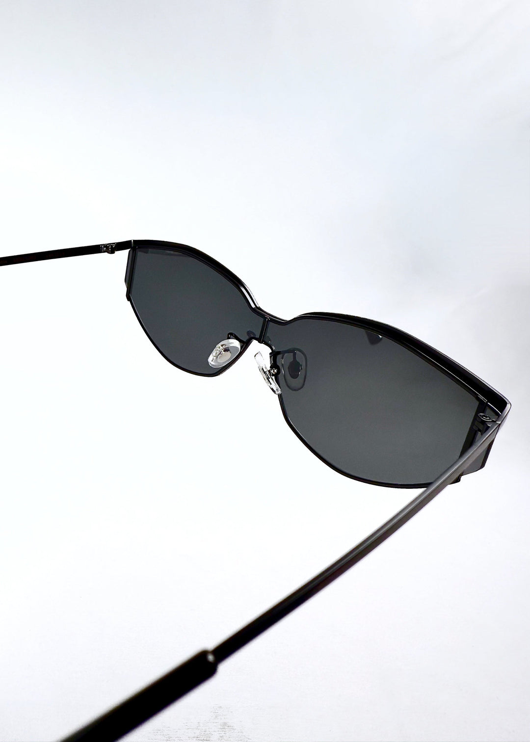 Inside view of Celestia – Matte Black sunglasses revealing the matte black inner arms and nose pad placement. 