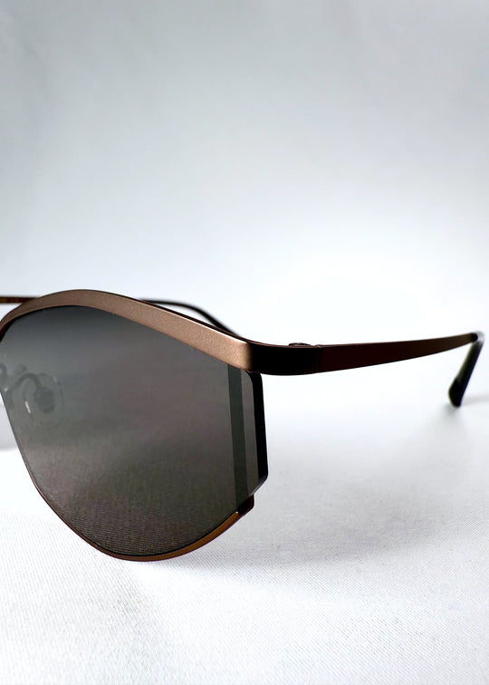 Close-up of the Celestia – Mocha Bronze’s semi-rimless frame, showcasing its sculpted metal browline and refined bronze finish. 