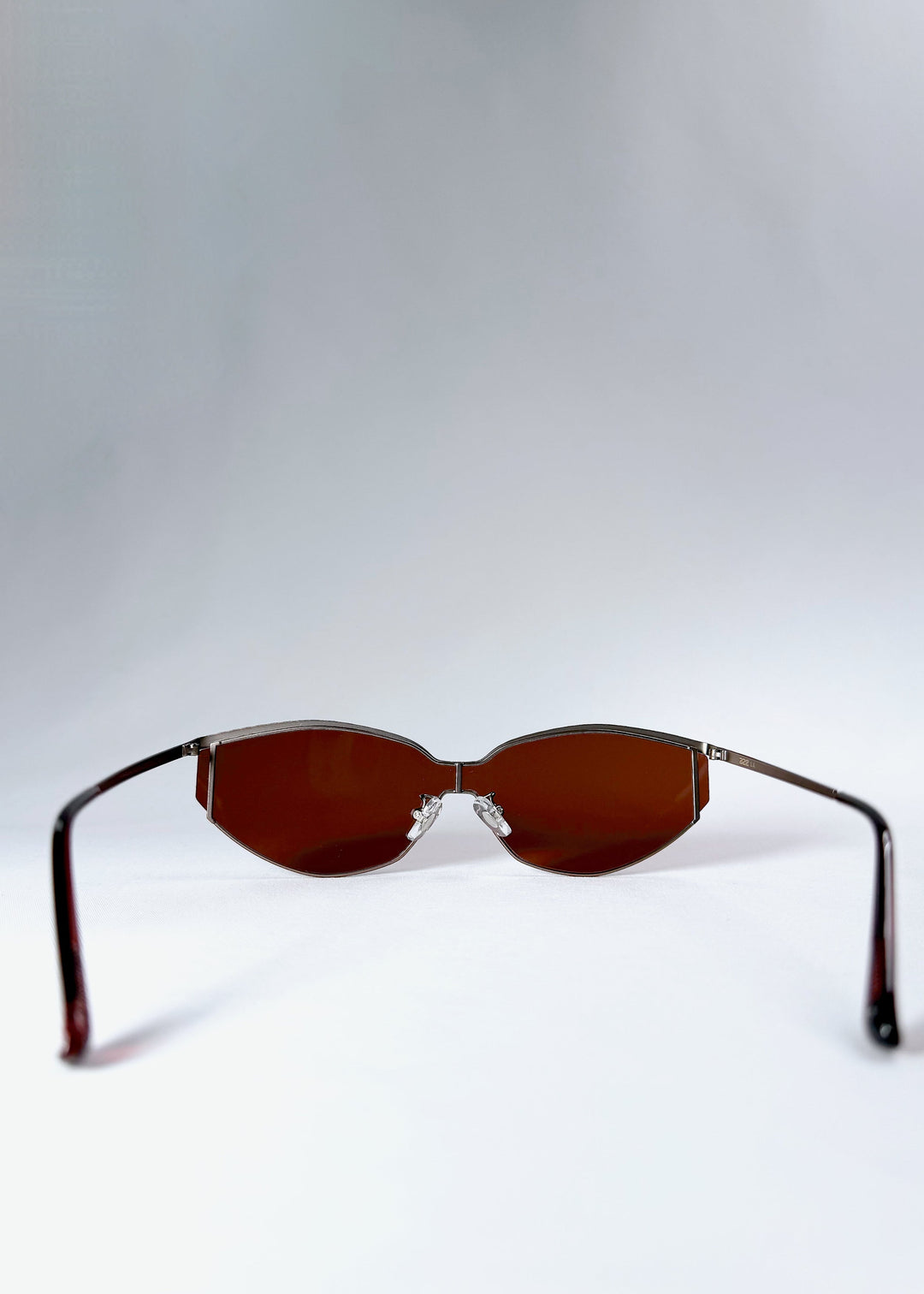 Back view of Celestia – Ruby Smoke sunglasses featuring adjustable nose pads and curved ear tips for comfort. 