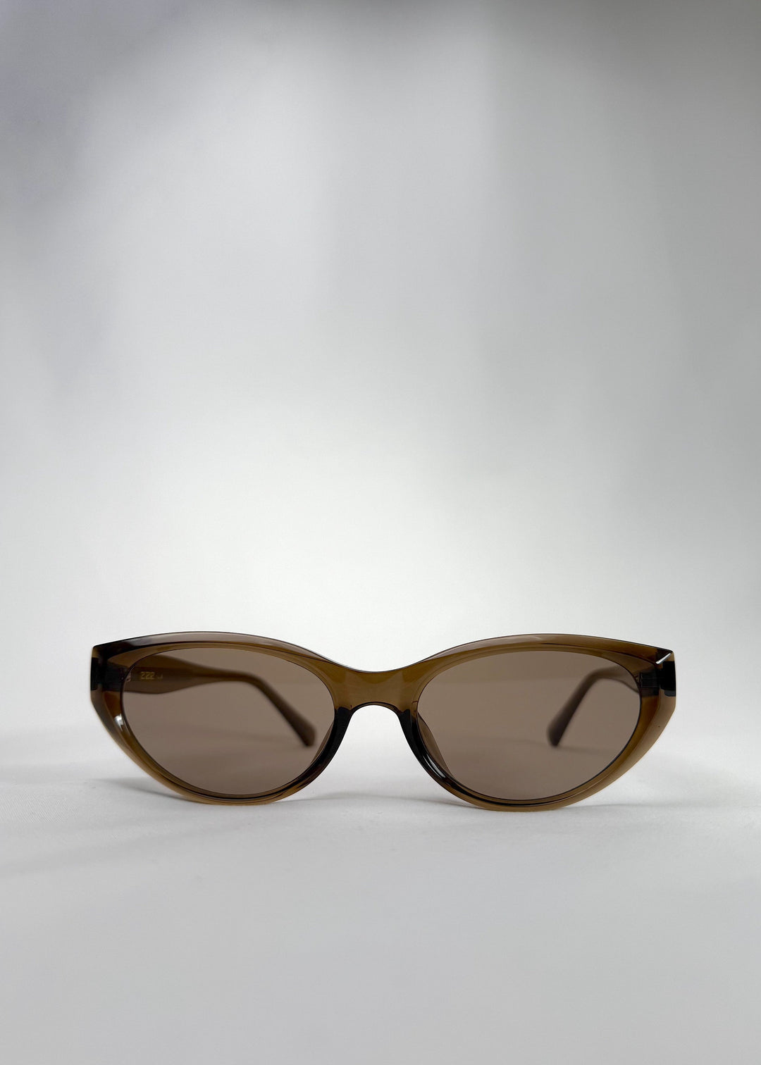Front view of Chara sunglasses in Champagne Brown, featuring a translucent champagne brown cat-eye acetate frame and UV400 lenses, showing the full front silhouette. 