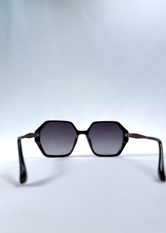 Back view of Ciel Arc sunglasses in Duskgold, featuring black and gold frame with dark lenses, showing the inside frame and open temples. 