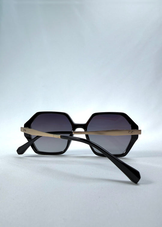 Folded back view of Ciel Arc sunglasses in Duskgold, featuring black and gold frame with dark lenses, showing the folded temples and back structure. 