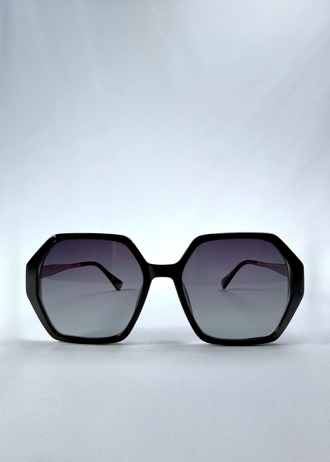 Front view of Ciel Arc sunglasses in Duskgold, featuring black and gold frame with dark lenses, showing the full front silhouette.