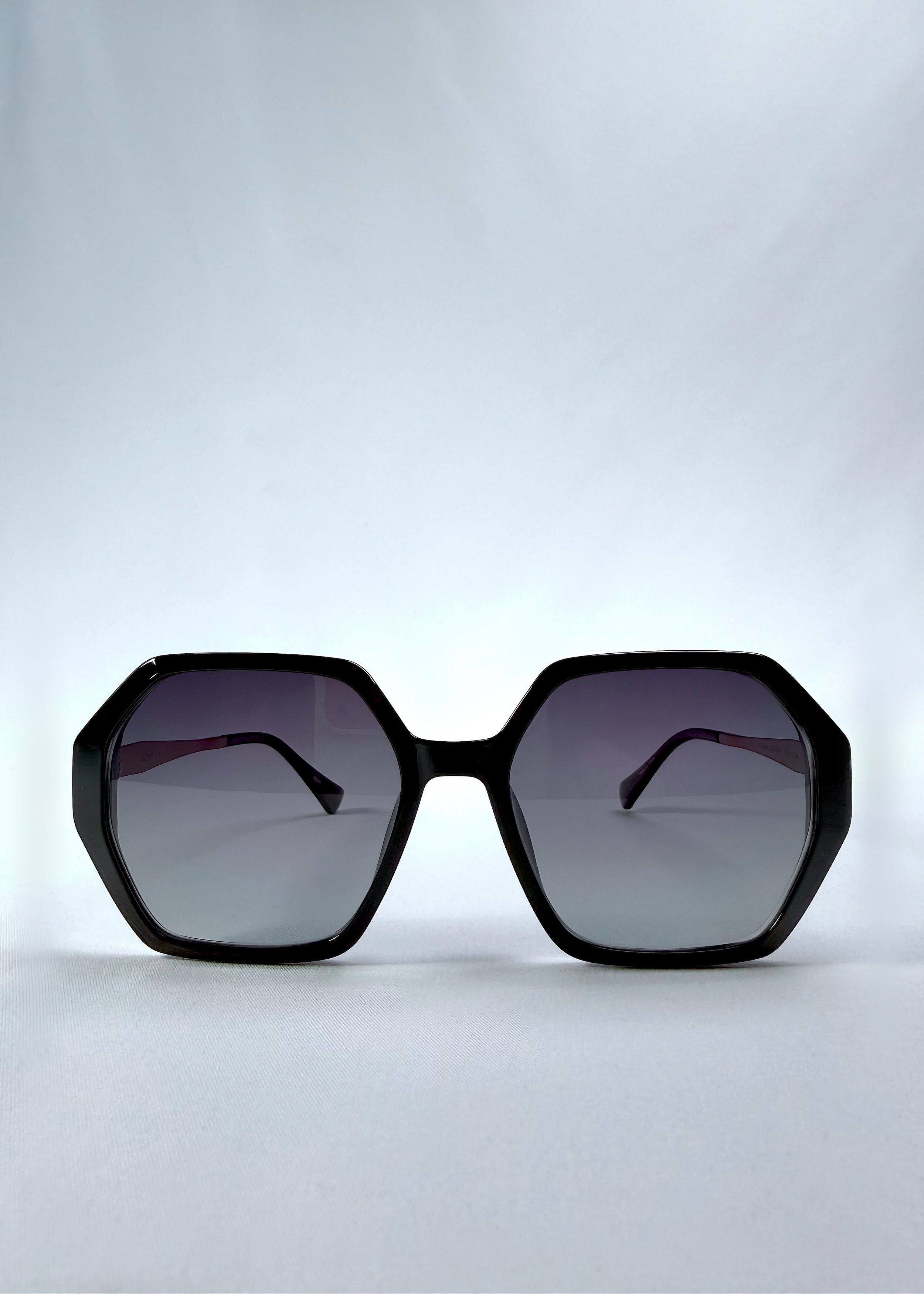 Front view of Ciel Arc sunglasses in Duskgold, featuring black and gold frame with dark lenses, showing the full front silhouette.