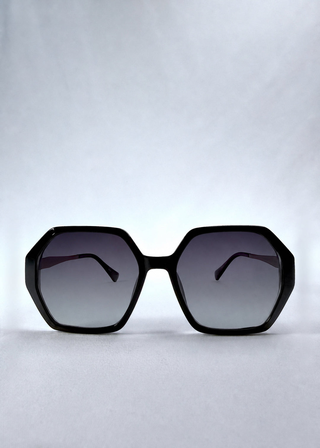 Front view of Ciel Arc sunglasses in Duskgold, featuring black and gold frame with dark lenses, showing the full front silhouette. 