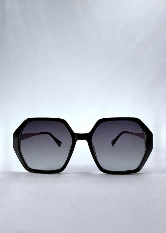 Front view of Ciel Arc sunglasses in Duskgold, featuring black and gold frame with dark lenses, showing the full front silhouette. 