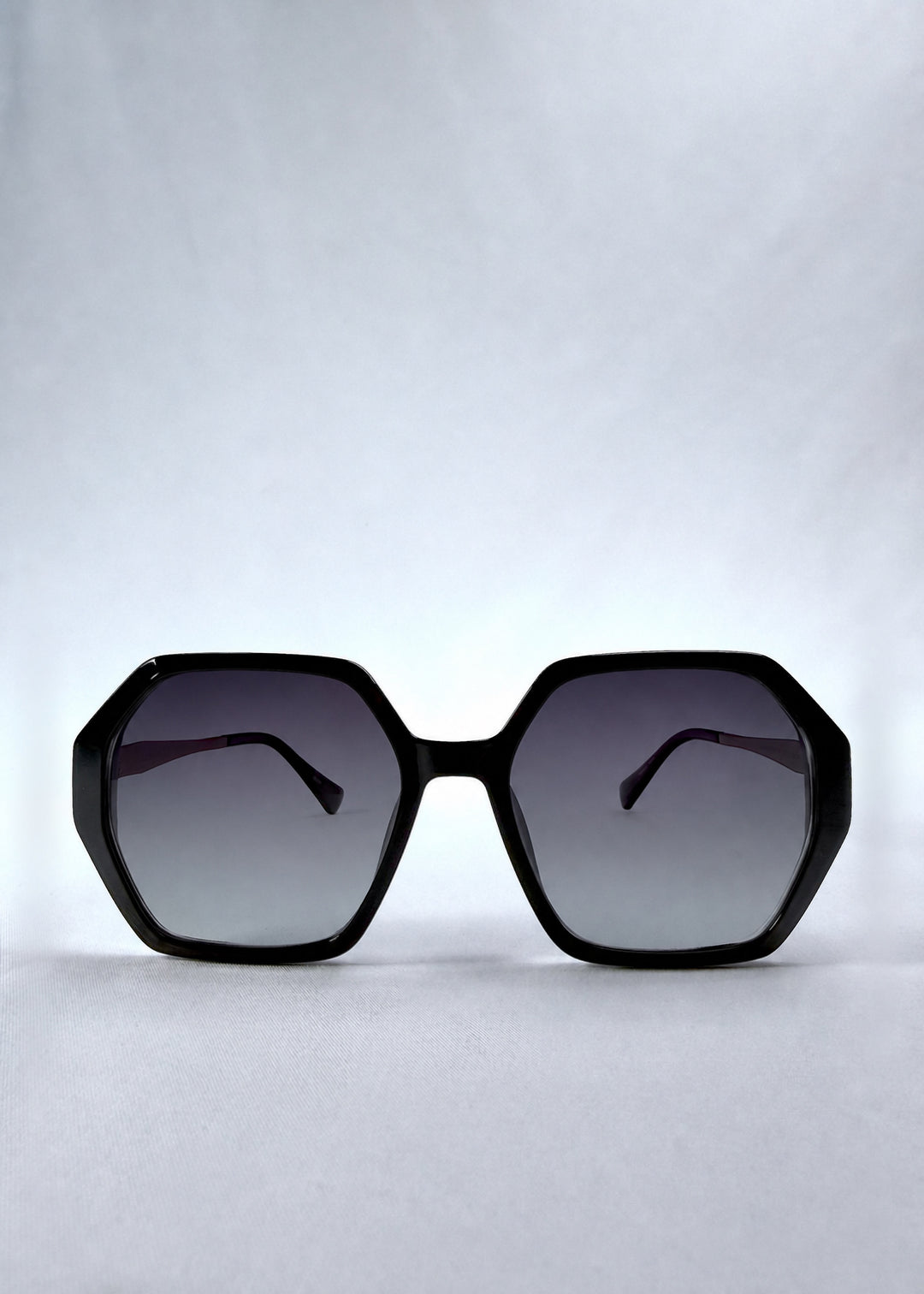 Front view of Ciel Arc sunglasses in Duskgold, featuring black and gold frame with dark lenses, showing the full front silhouette.