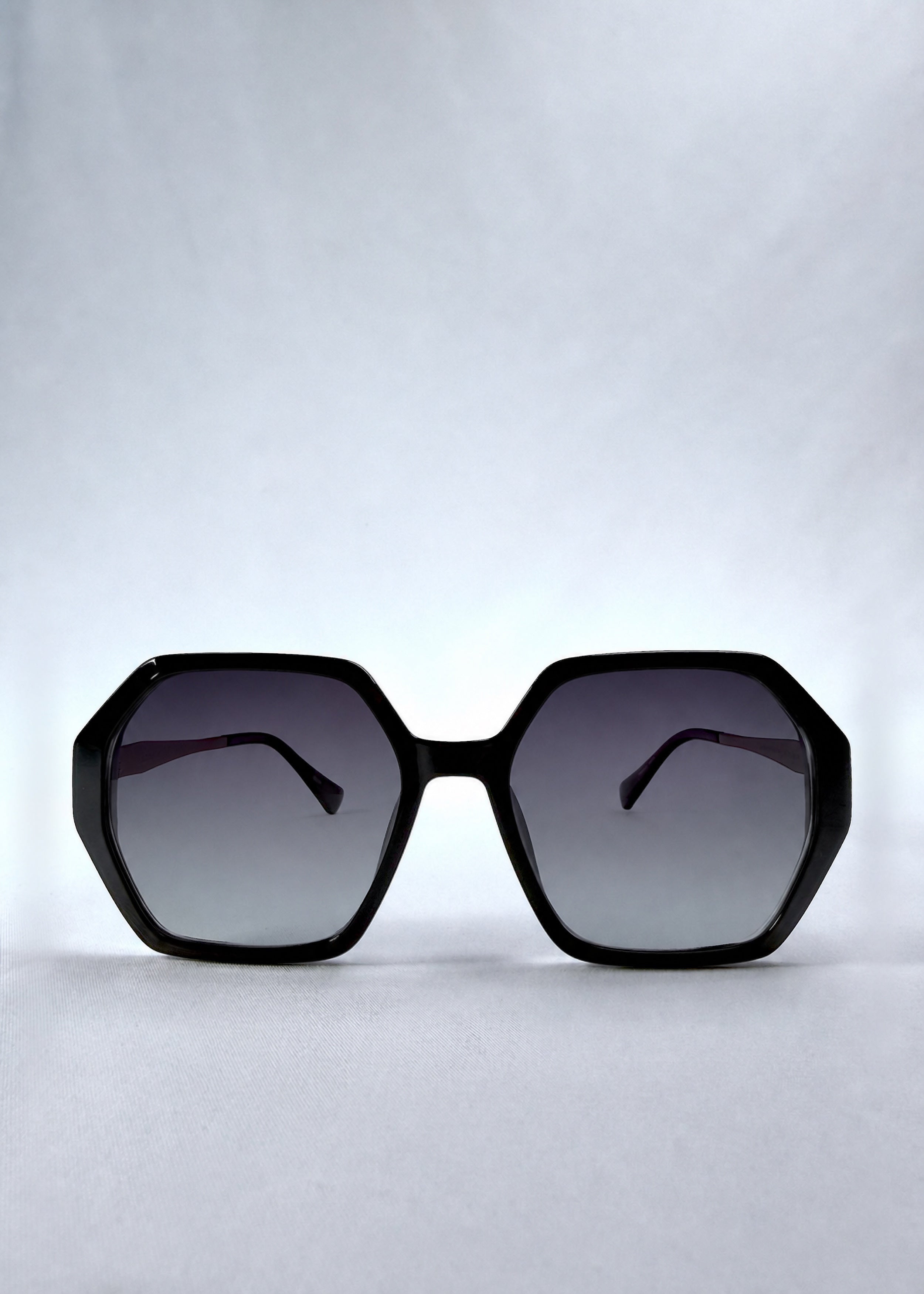 Front view of Ciel Arc sunglasses in Duskgold, featuring black and gold frame with dark lenses, showing the full front silhouette.