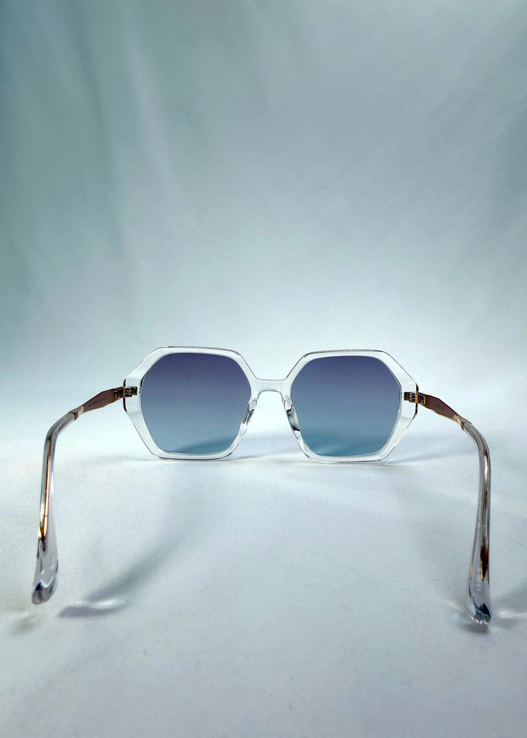 Back view of Ciel Arc sunglasses in Glacial Blue, featuring clear frame with blue gradient lenses, showing the inside frame and open temples.