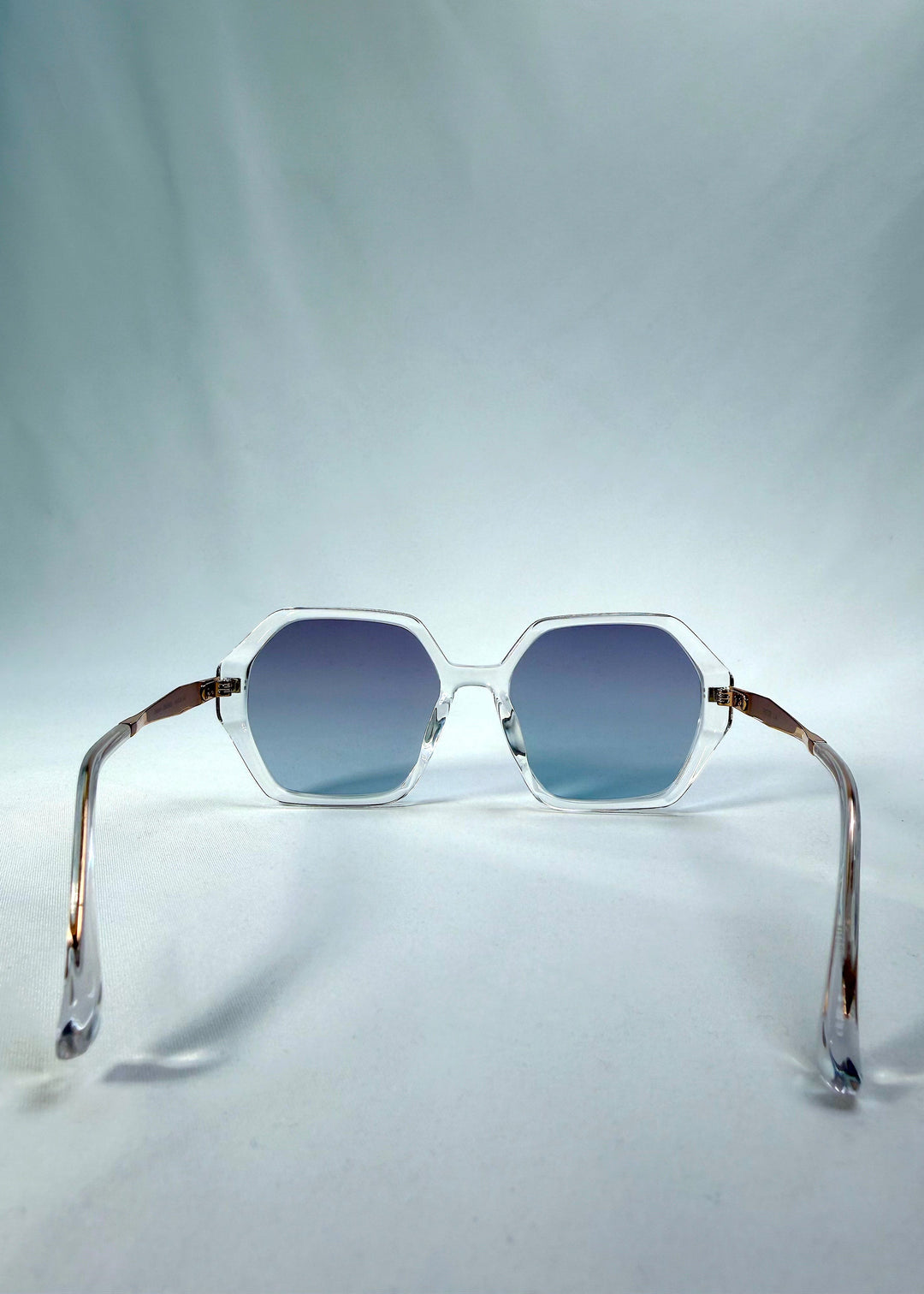 Back view of Ciel Arc sunglasses in Glacial Blue, featuring clear frame with blue gradient lenses, showing the inside frame and open temples. 