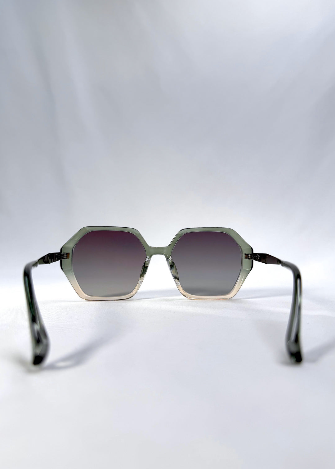 Back view of Ciel Arc sunglasses in Jade Phase, featuring green-toned frame and smoky green lenses, showing the inside frame and open temples.