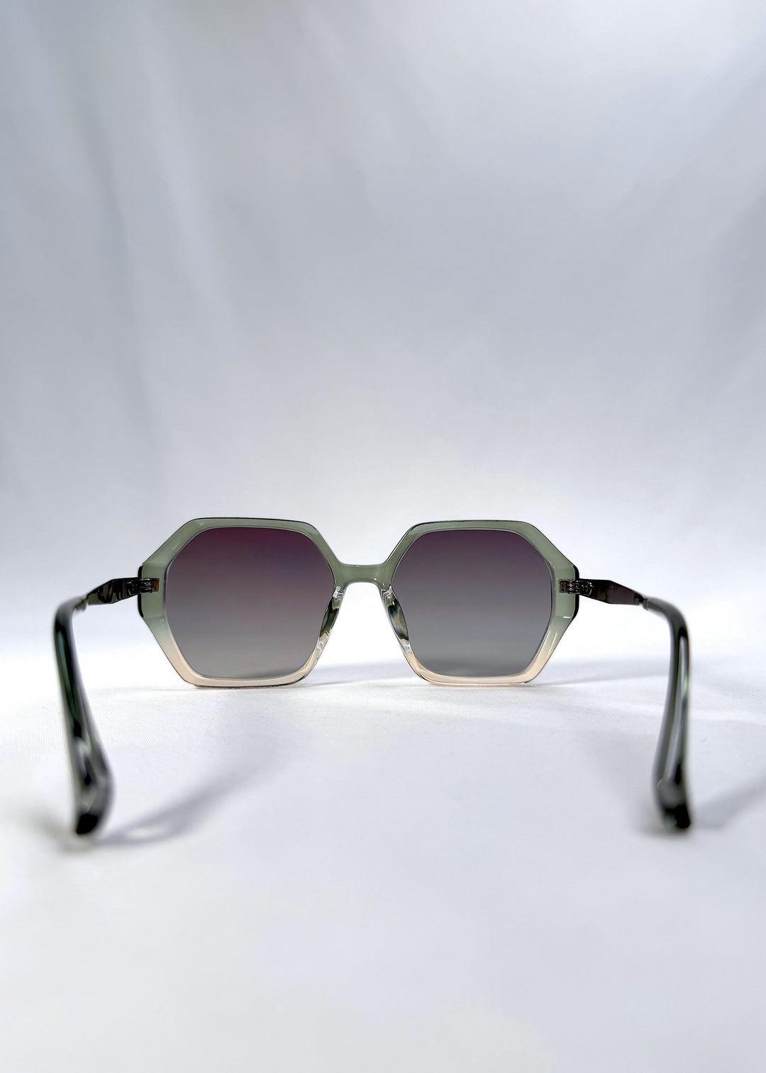 Back view of Ciel Arc sunglasses in Jade Phase, featuring green-toned frame and smoky green lenses, showing the inside frame and open temples. 