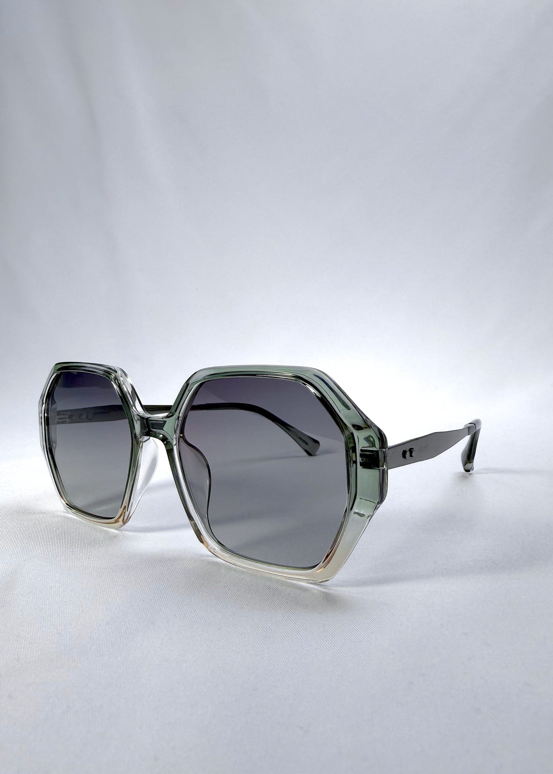 Three-quarter front view of Ciel Arc sunglasses in Jade Phase, featuring green-toned frame and smoky green lenses, showing the front shape and temple profile. 