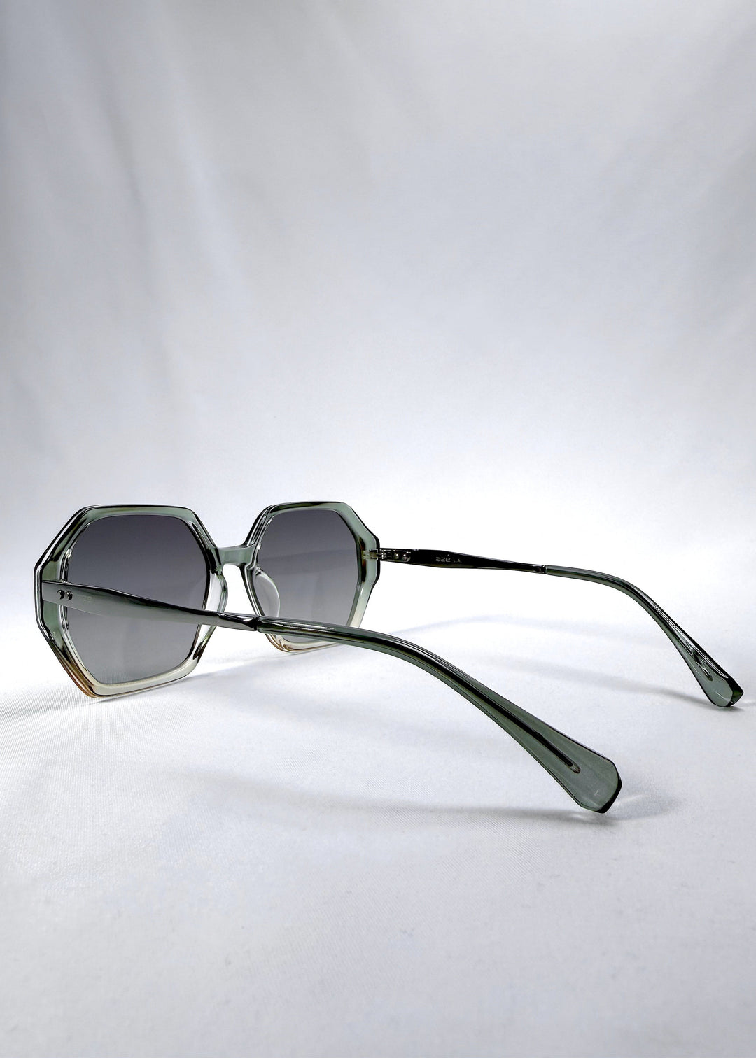 Side-angle view of Ciel Arc sunglasses in Jade Phase, featuring green-toned frame and smoky green lenses, showing the lens shape and side temple profile. 