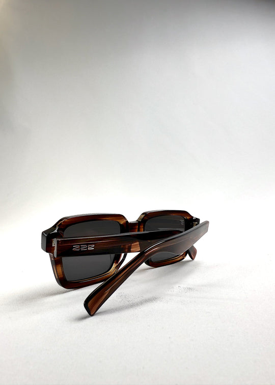 Crest sunglasses in Chestnut Marble with folded temples, showing logo detail and acetate marbling. 