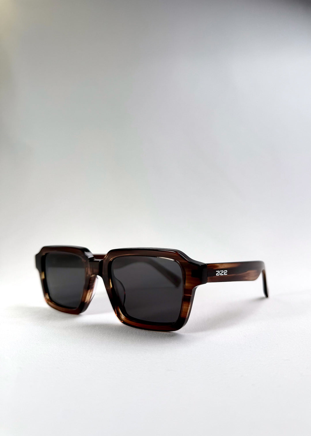 Angled front shot of Crest in Chestnut Marble, capturing the bold structure and earthy frame texture. 