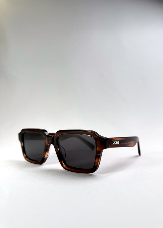 Angled front shot of Crest in Chestnut Marble, capturing the bold structure and earthy frame texture. 