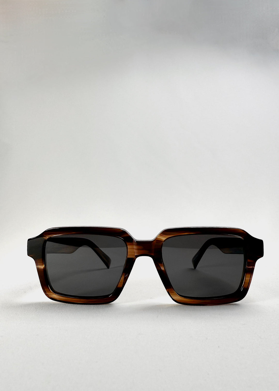 Front view of Crest sunglasses in Chestnut Marble, highlighting the squared frame and dark polarized lenses. 