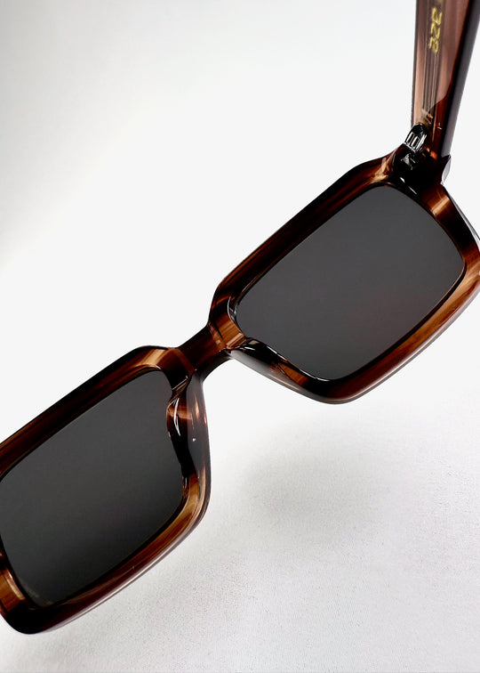 Close-up of the hinge and lens corner of Crest in Chestnut Marble, showcasing the smooth blend of form and function in its sculpted acetate design. 