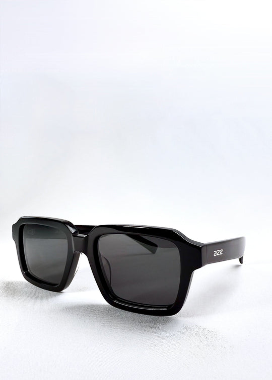 Angled product view of Crest - Obsidian Black sunglasses highlighting the thick acetate frame and clean squared lens design. 