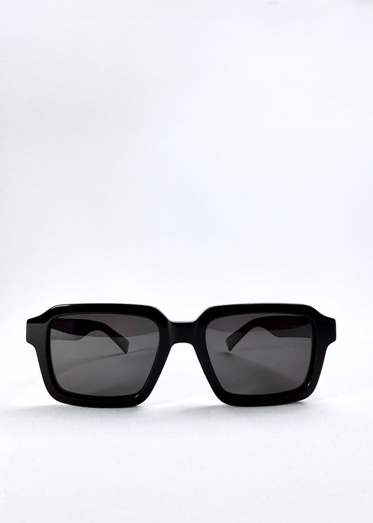 Front view of Crest - Obsidian Black sunglasses showing the bold square silhouette and UV400 polarized lenses in high-gloss black acetate 