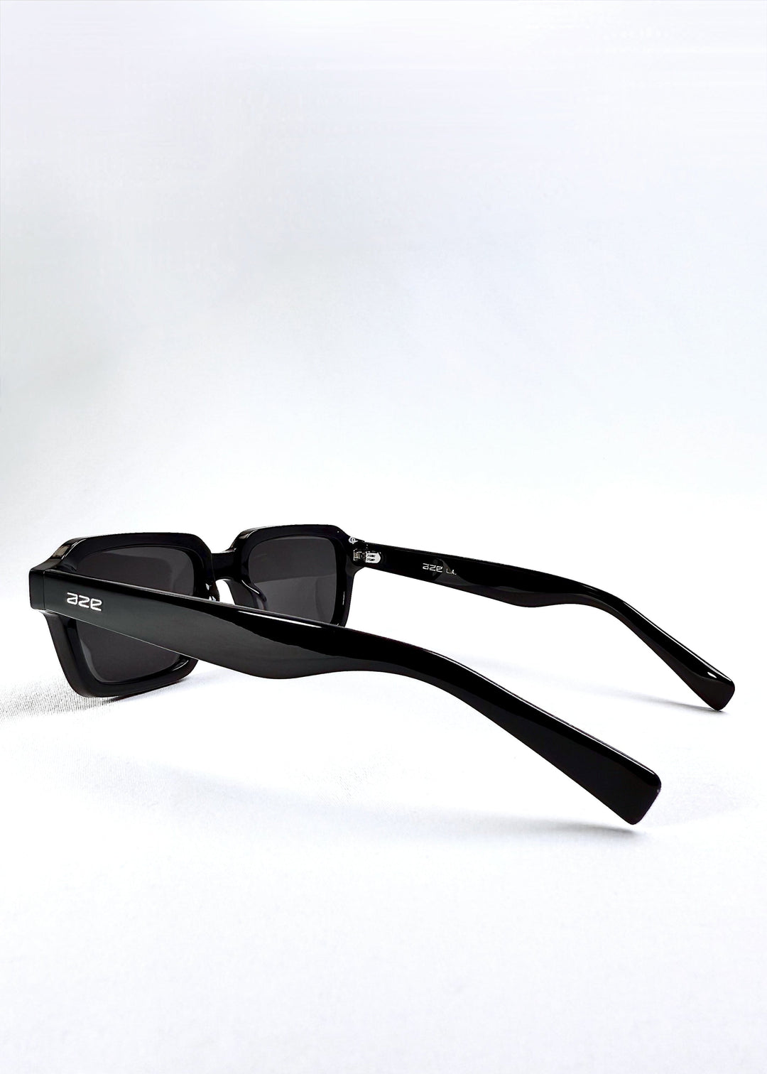 Close-up of the Aze logo on the temple arm of Crest - Obsidian Black sunglasses, emphasizing brand detail and craftsmanship. 