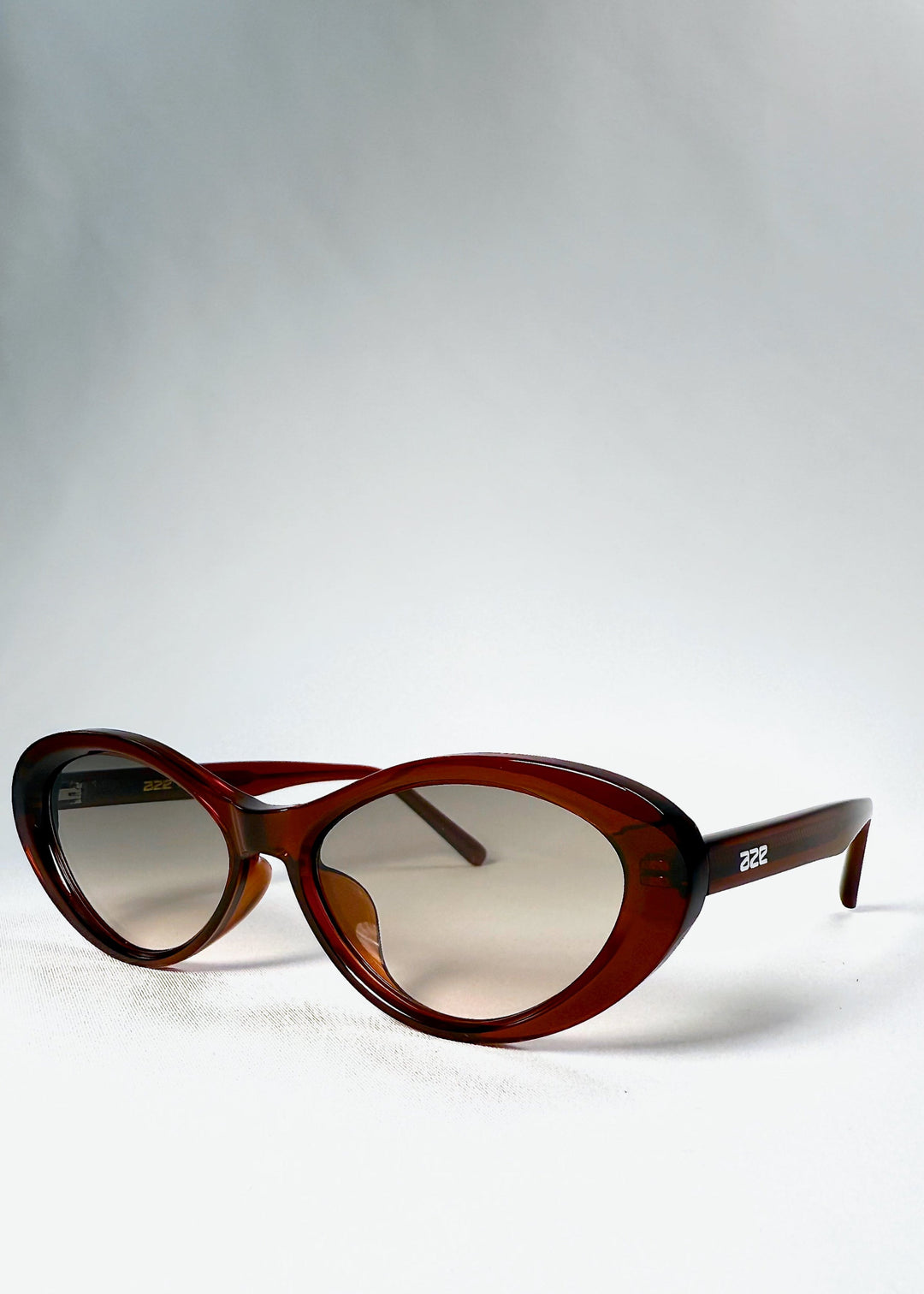 Three-quarter front view of Dagger sunglasses in Crimson Mist showing the translucent red acetate frame. 
