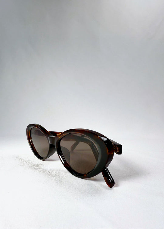 Folded side view showing the gentle curve of the frame and the play of dark and amber hues (Dagger, Ember Fade). 