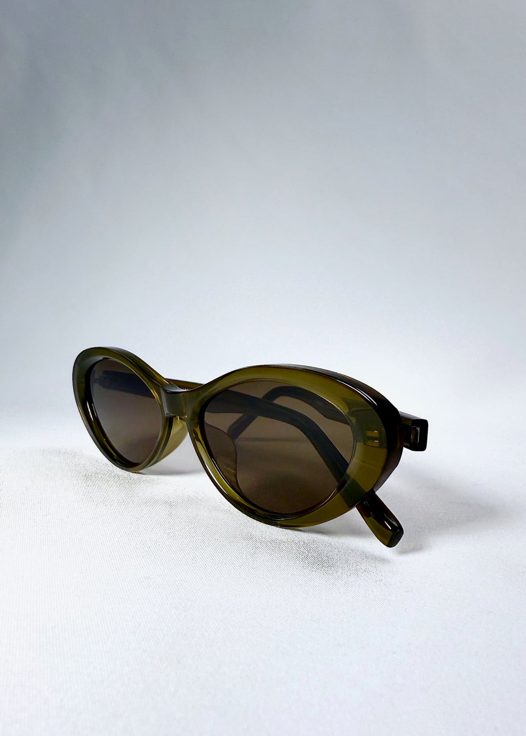 Folded view of Dagger sunglasses in Olive Shadow highlighting the compact shape and hinge flexibility. 