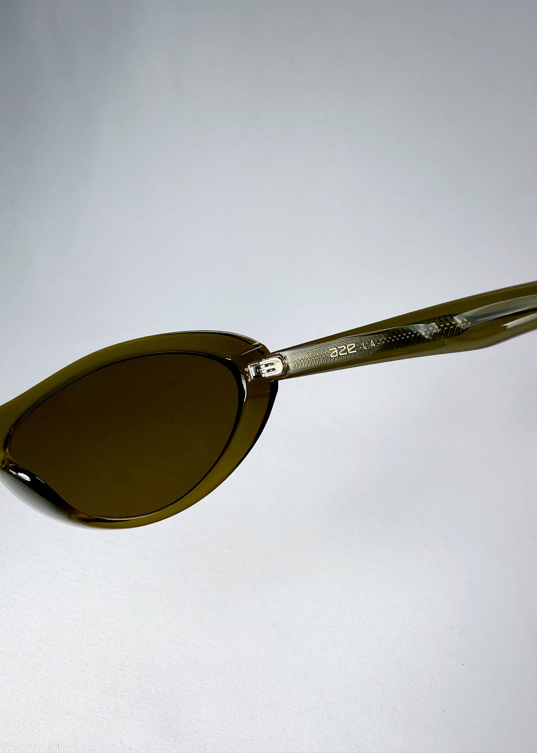 Close-up of Dagger’s temple in Olive Shadow revealing engraved metal core and Aze logo detailing. 